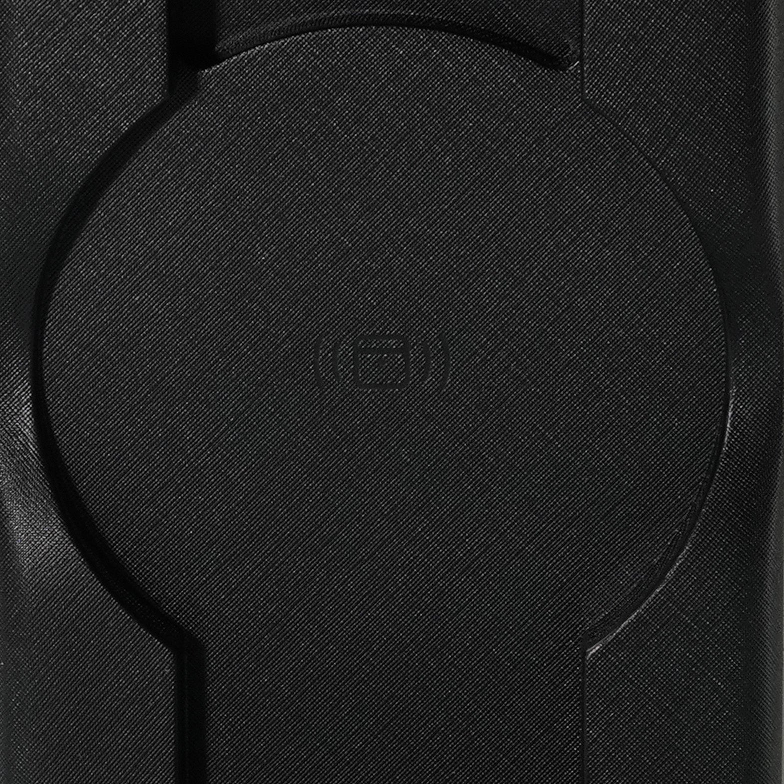 Close-up of a textured black geometric pattern with a circular indention in the center, featuring a symbol that may indicate wireless charging. The versatile Urban PowerBuddy 2.0 5-in-1 Wireless Powerbank can charge up to 5 devices simultaneously with its innovative, convertible design.