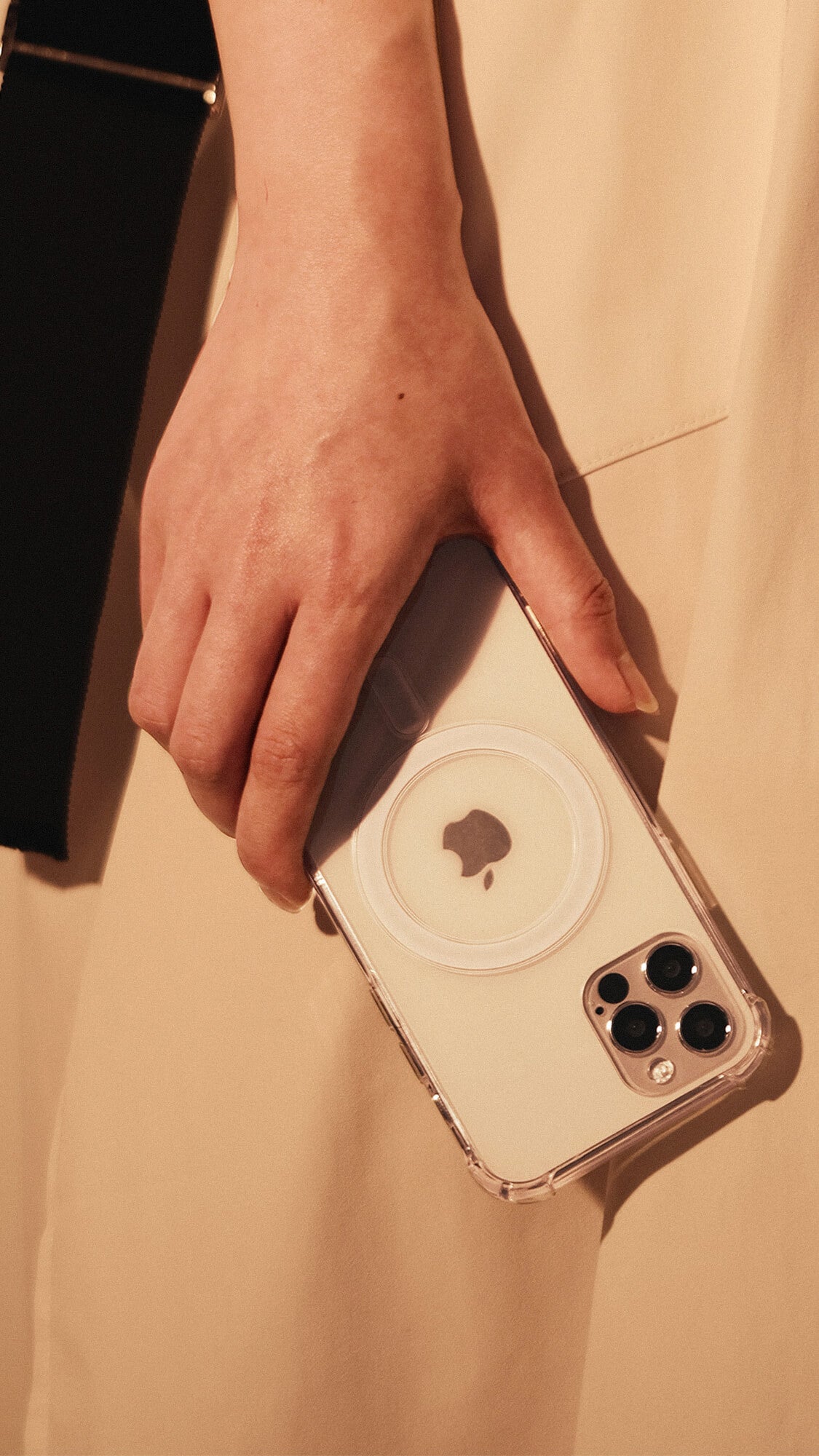 lady in white clothing holding an urbanist clear magsafe case for iphone 14